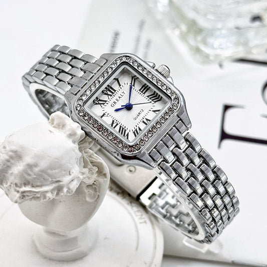 Silver watch with diamond accents on a white surface