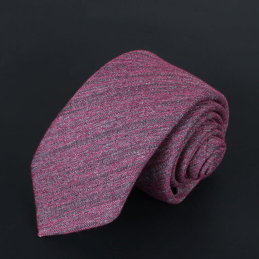 Rolled-up pink and gray tie on a black background