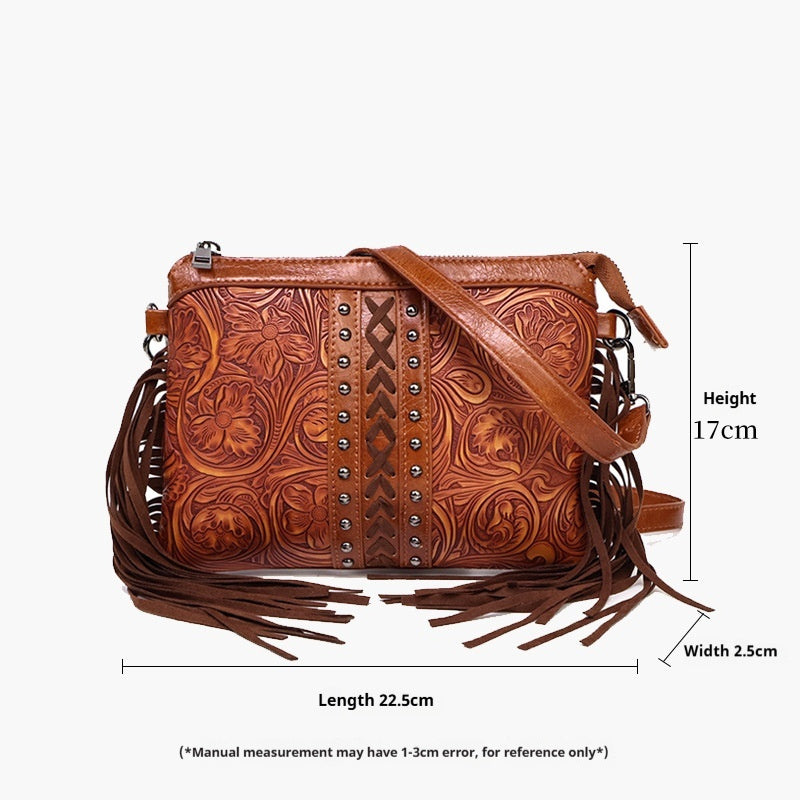 Brown embossed crossbody bag with studded center strip, tassel fringe, adjustable shoulder strap