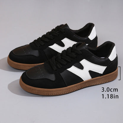 Women's low-top color-block sneakers, black with white panels, lace-up style and gum outsole.