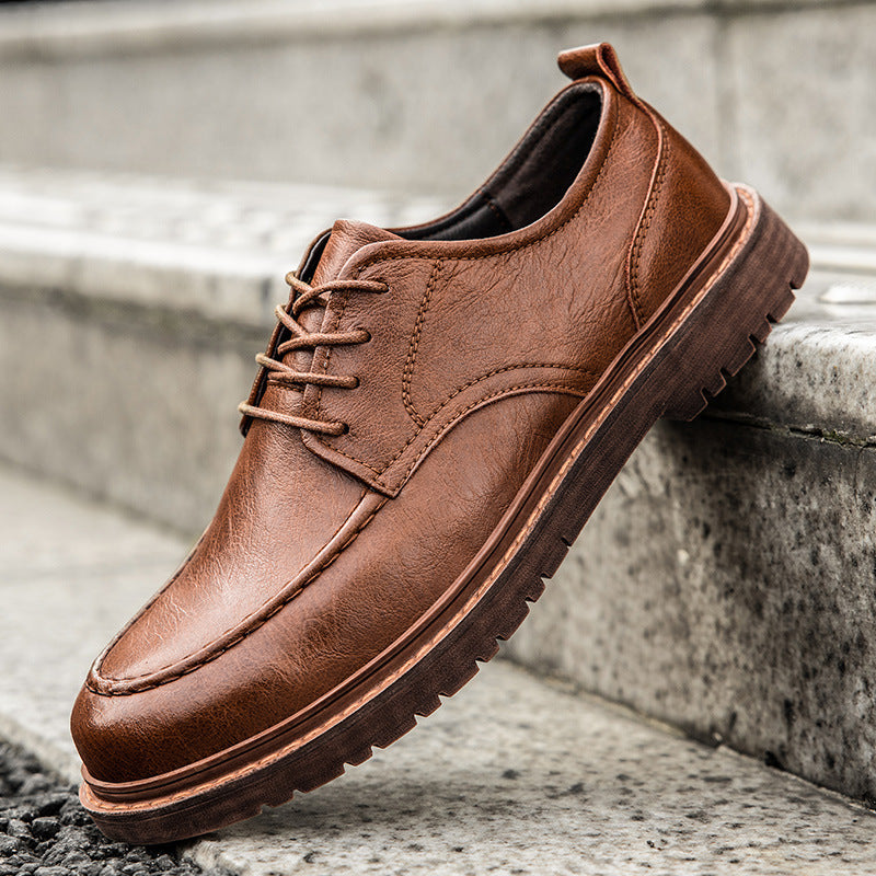 Brown leather shoe on a concrete surface