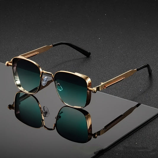 Gold-framed sunglasses with green lenses on a reflective black surface