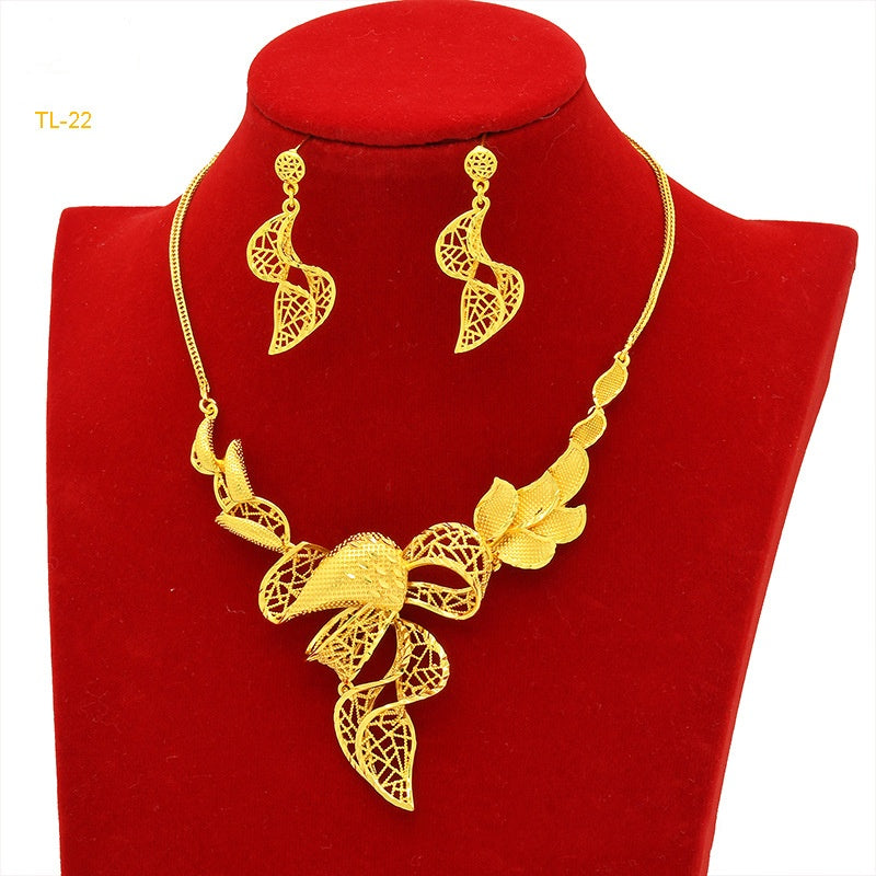 Gold necklace and earrings set on a red velvet stand