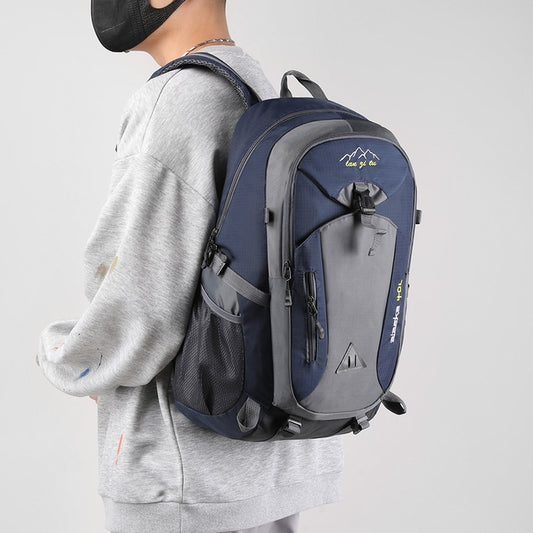 Person wearing a blue and gray backpack on a plain background