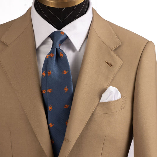 Beige suit with a blue tie and white shirt on a mannequin