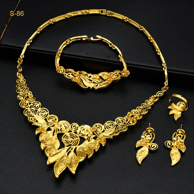 Gold jewelry set including necklace, bracelet, and earrings on a black background