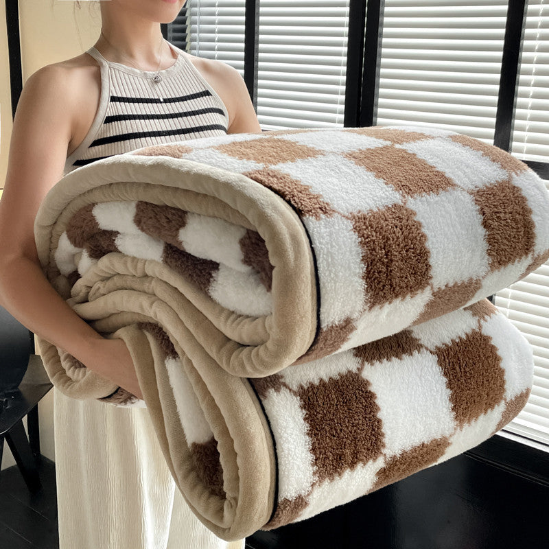 Brown and white check plaid fleece blanket rolled with beige edging
