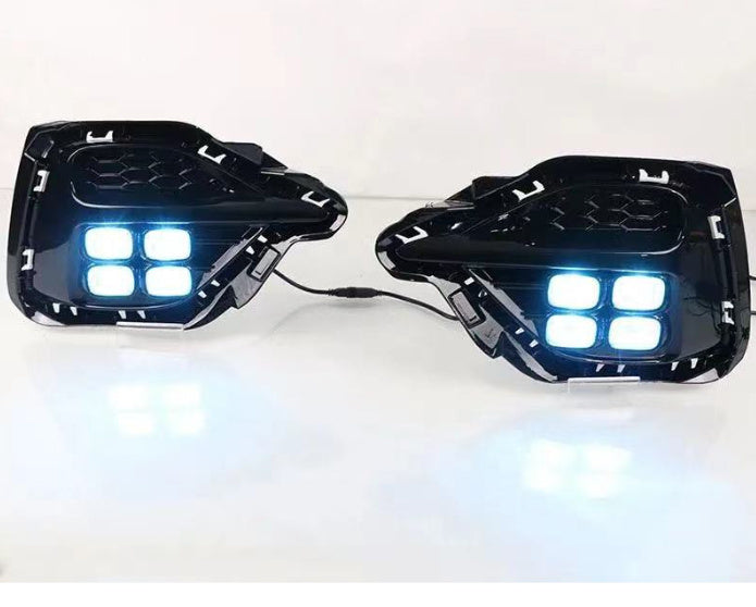 Pair of black LED turn signal fog lamps with bright blue-white lights on