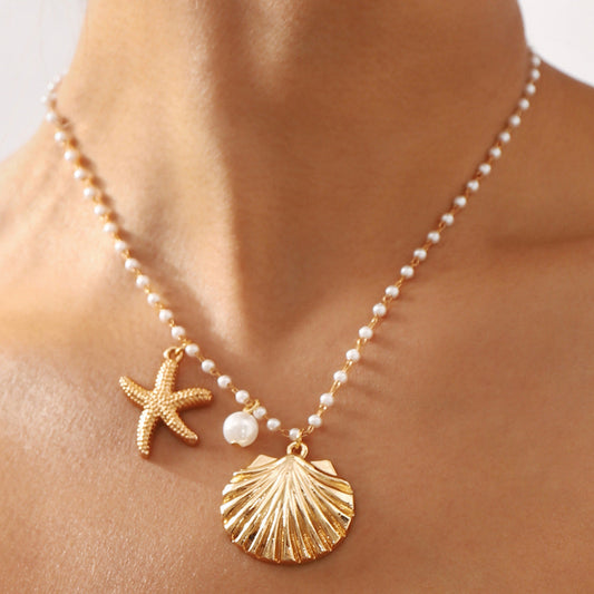 Necklace with gold shell and starfish pendants on a person's neck