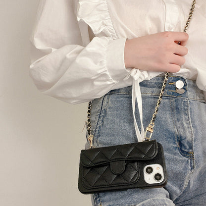 Person holding a black quilted phone case with a chain strap against a neutral background