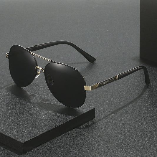 Black sunglasses with gold accents on a gray background