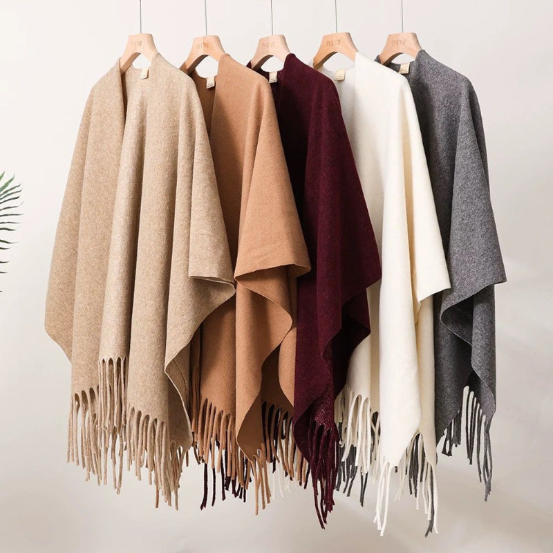 Tassel-fringe travel cape with draped silhouette, shown in multiple colors