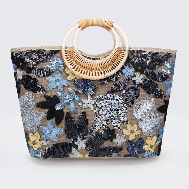 Large woven cotton tote bag with sequined blue floral pattern and rattan half-moon handle