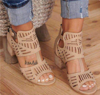 Beige open-toe sandals worn on a wooden floor