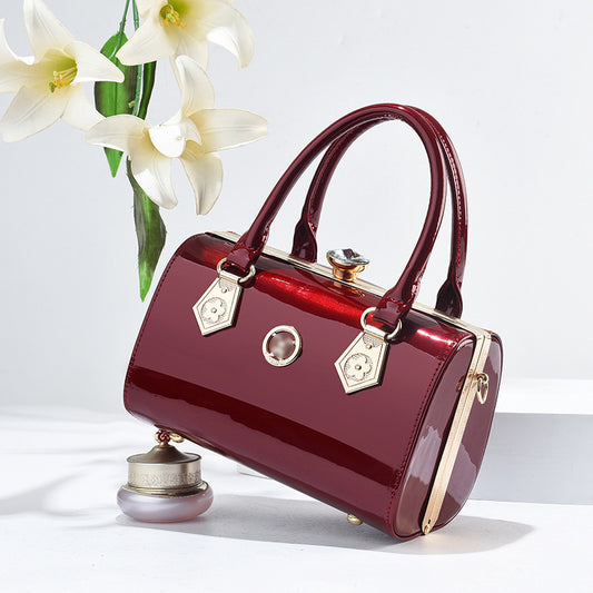 Red handbag with gold accents on a white background with flowers