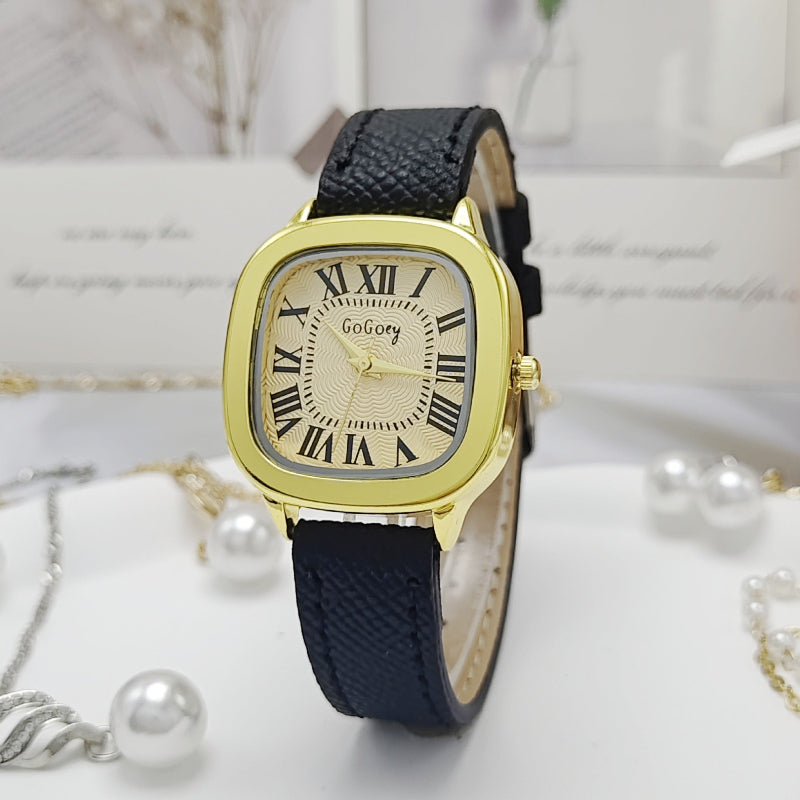 Women’s retro Roman dial leather strap watch with gold case and navy leather strap, front view.