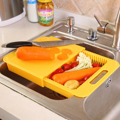 Yellow cutting board with knife and vegetables in a kitchen sink