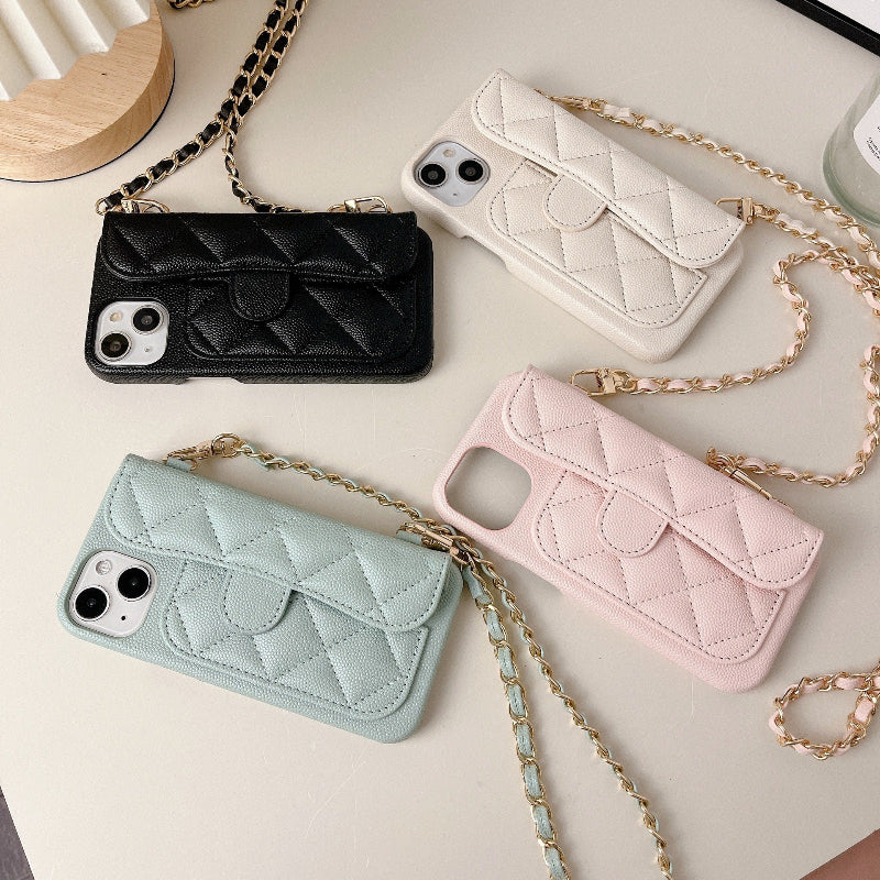 Four quilted phone cases in black, white, pink, and blue with chain straps on a light surface.