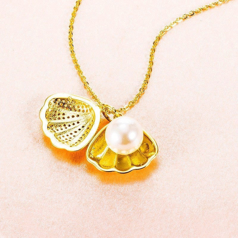 Round pearl set in gold tone seashell pendant with rhinestone accents on necklace