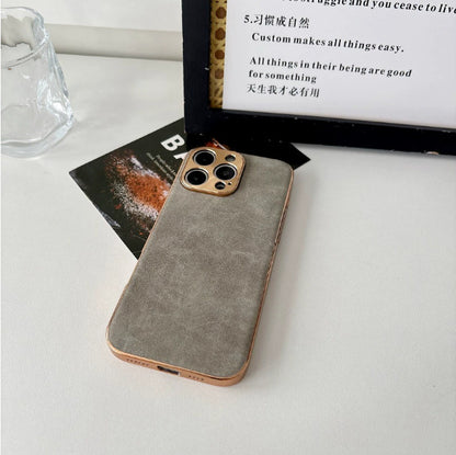 Phone case with a textured gray back and gold edge on a white surface.