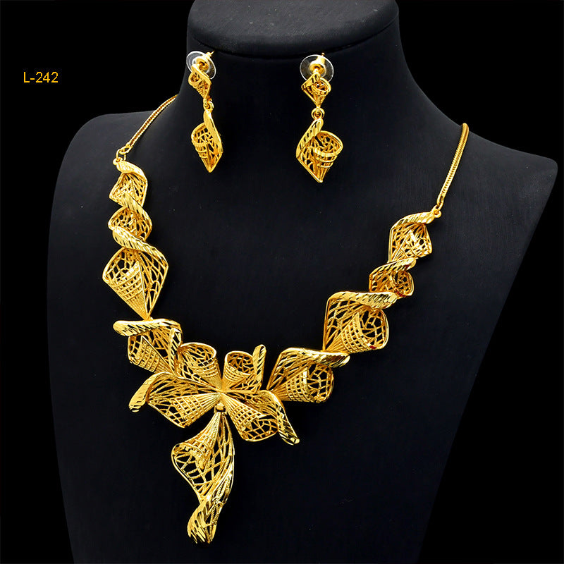 Gold necklace and earrings set on a black mannequin