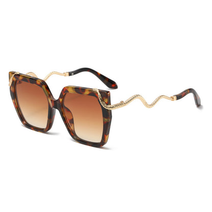 Sunglasses with tortoiseshell frame and gold chain on a white background