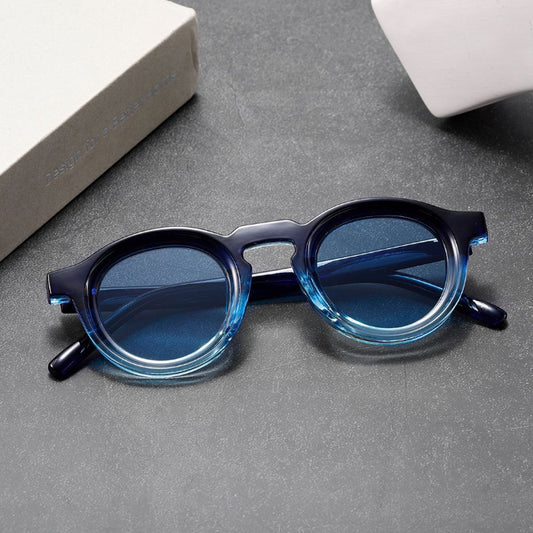 Blue round sunglasses on a gray surface