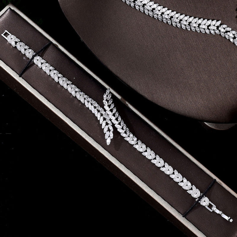 Zircon bracelet and necklace with leaf connectors, shown on gray gift cases