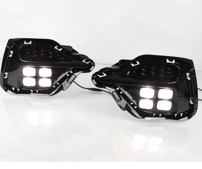 Pair of black fog lamp modules with four bright white LEDs and visible wiring