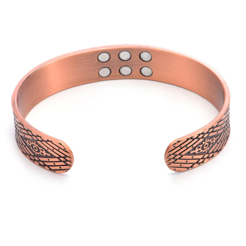 Copper-tone magnetic bracelet with etched end panels and round magnet inlays across top.