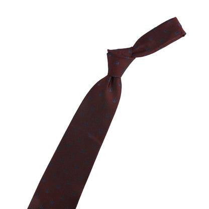 Brown tie with blue patterns, violin-shaped pin, and decorative pin on a white background