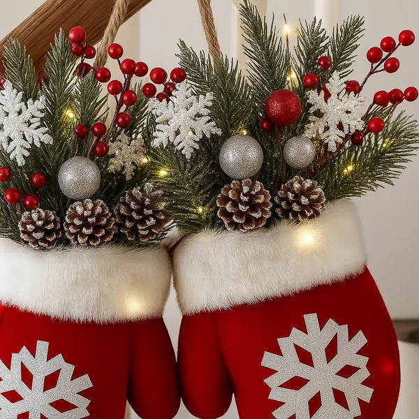 Close-up Christmas glove ornament with lit evergreen wreath, pinecones, red berries, snowflake gloves