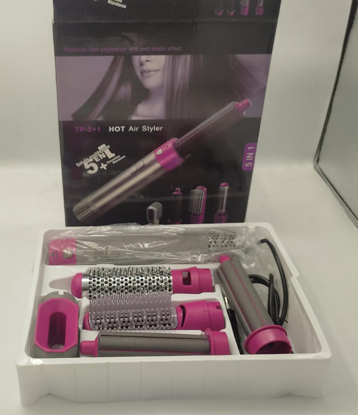 Hot air styling brush set in a molded tray with multiple pink-and-gray roller attachments