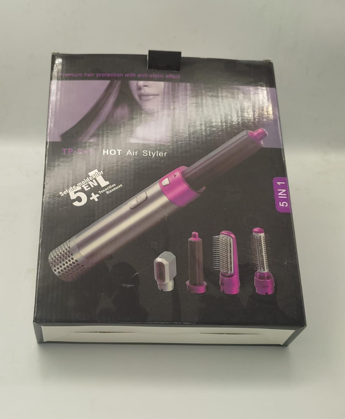 Hot air styling brush retail box showing a pink-and-gray hot air tool and accessories