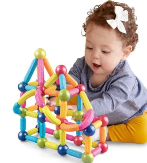 Colorful magnetic building sticks set with ball joints held by a toddler during play