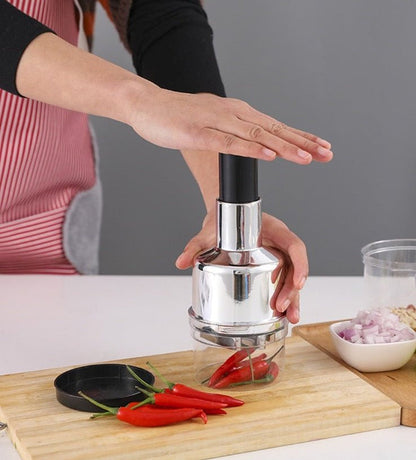 Manual press vegetable cutter with metal press head and base, slicing vegetables on board