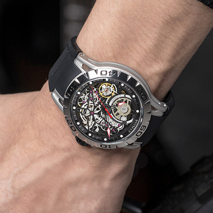 Close-up of a person's wrist wearing a black and silver watch with a visible mechanical movement.