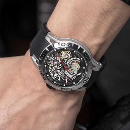 Close-up of a person's wrist wearing a black and silver watch with a visible mechanical movement.