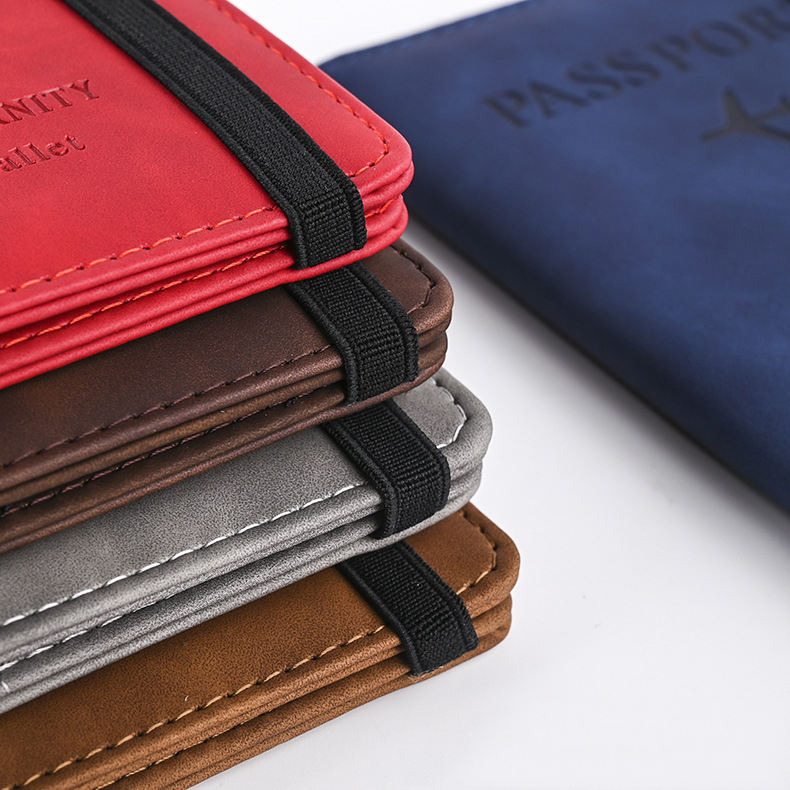 Leather passport covers in red, brown, gray, and tan, each secured with a black elastic band.