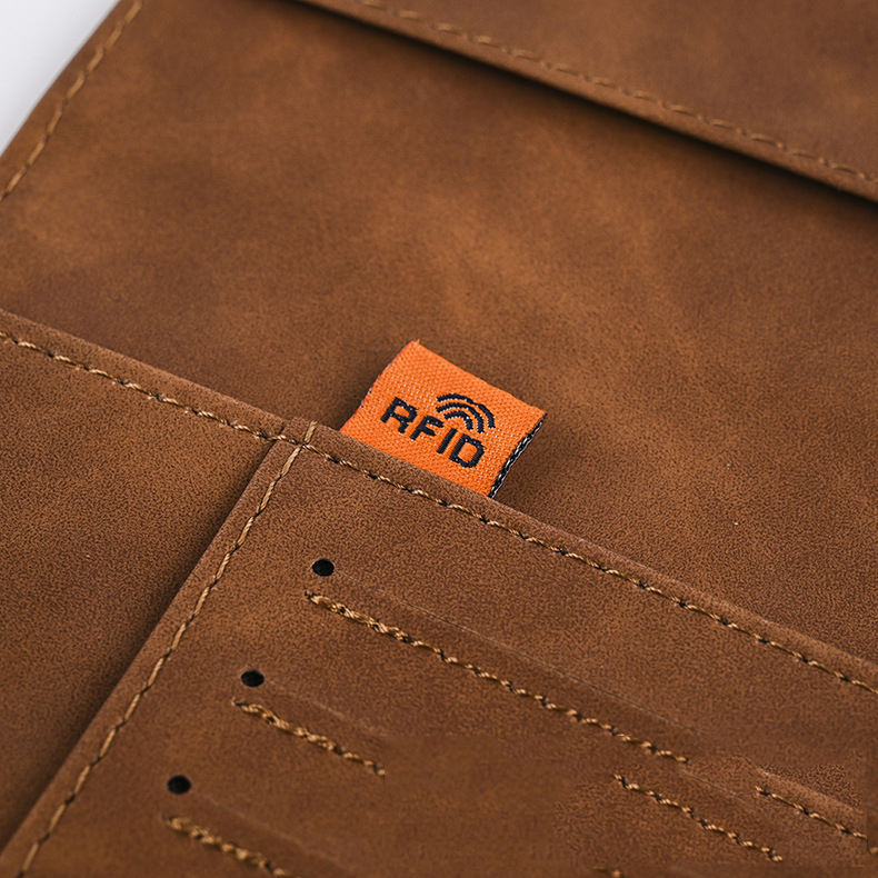 Brown leather passport cover detail showing an RFID label and stitched card slots.