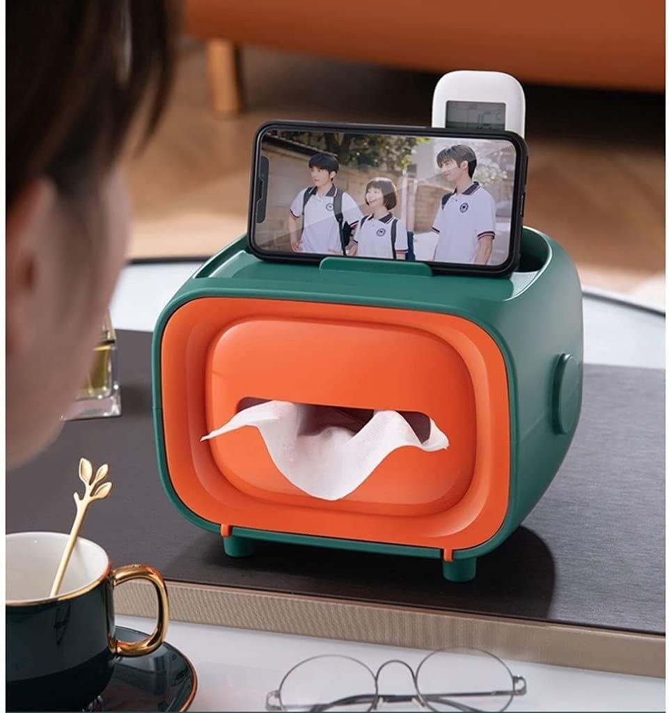 Retro TV tissue box in green and orange, with tissues dispensing and a phone resting on top.