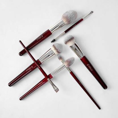 Burgundy makeup brushes with silver ferrules, including a dual-ended brow brush