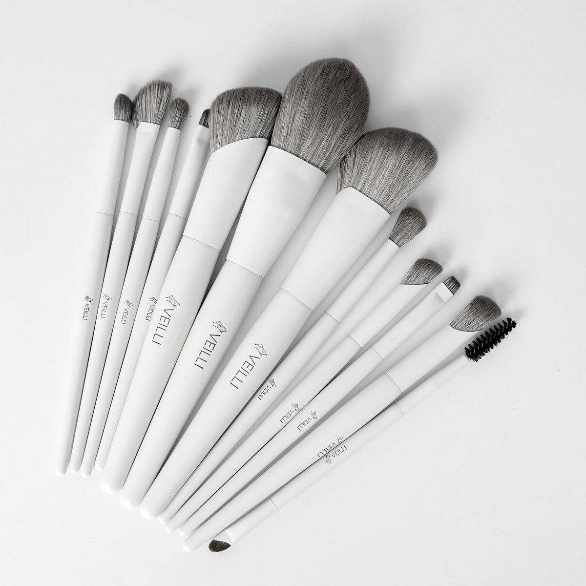 White-handled makeup brush set with assorted gray bristles and brow comb