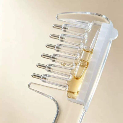 Close-up of clear applicator comb teeth with metal rollers and a liquid-filled reservoir.