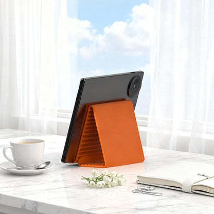 Orange silicone stand supports a tablet in landscape orientation.