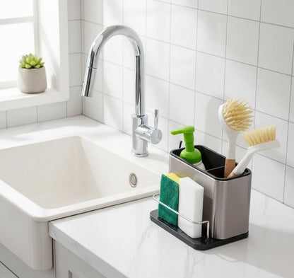 Stainless steel sink rack holding soap, dish brushes, a sponge, and a scrub pad beside a sink