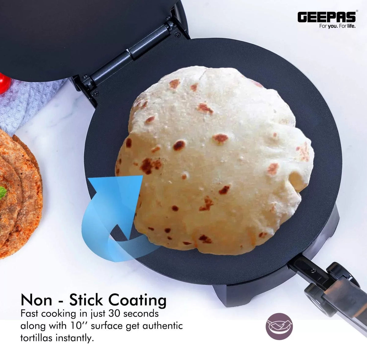 Open electric roti maker cooking a puffed flatbread on its black nonstick plate