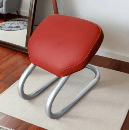 Sujood comfort aid seat with a red padded cushion and silver tubular frame