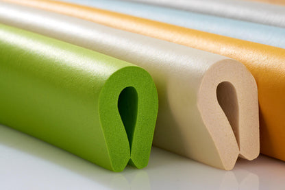 Close-up of green and beige foam edge guards with U-shaped profiles