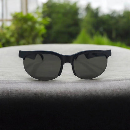 Front view of black wireless headset glasses with dark tinted lenses.